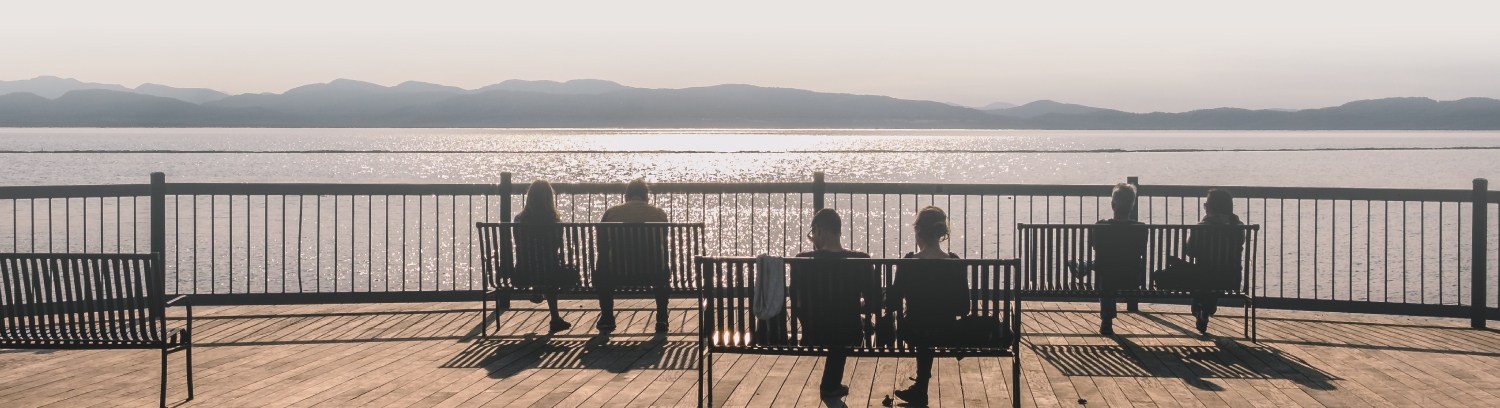 various people sitting on benches at the waterfront